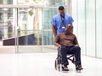 caregiver assisting elder man sitting on a wheelchair